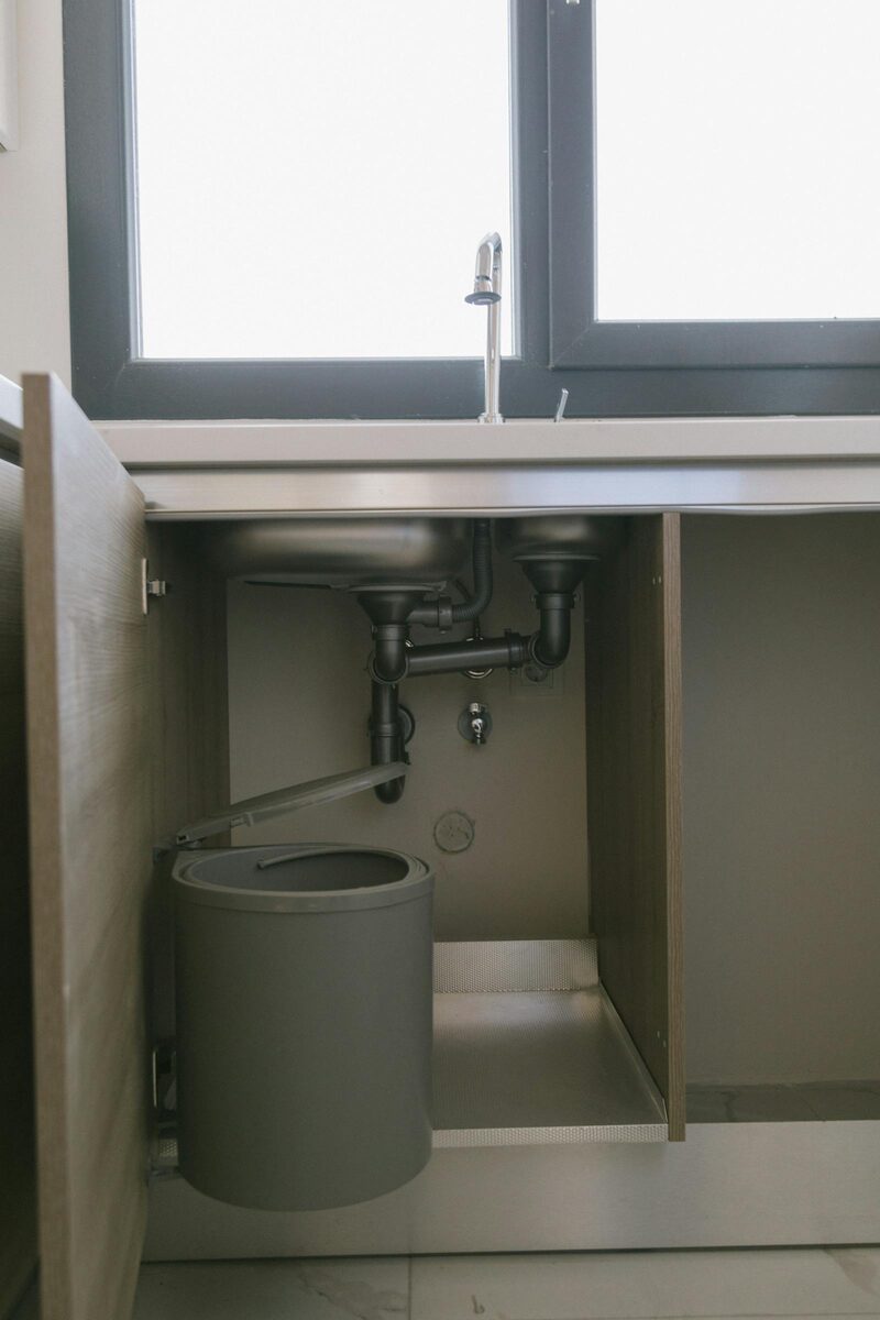 Clean under-sink drainage pipework in a bright Burnaby home